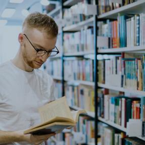 homme lisant un livre bibliothèque